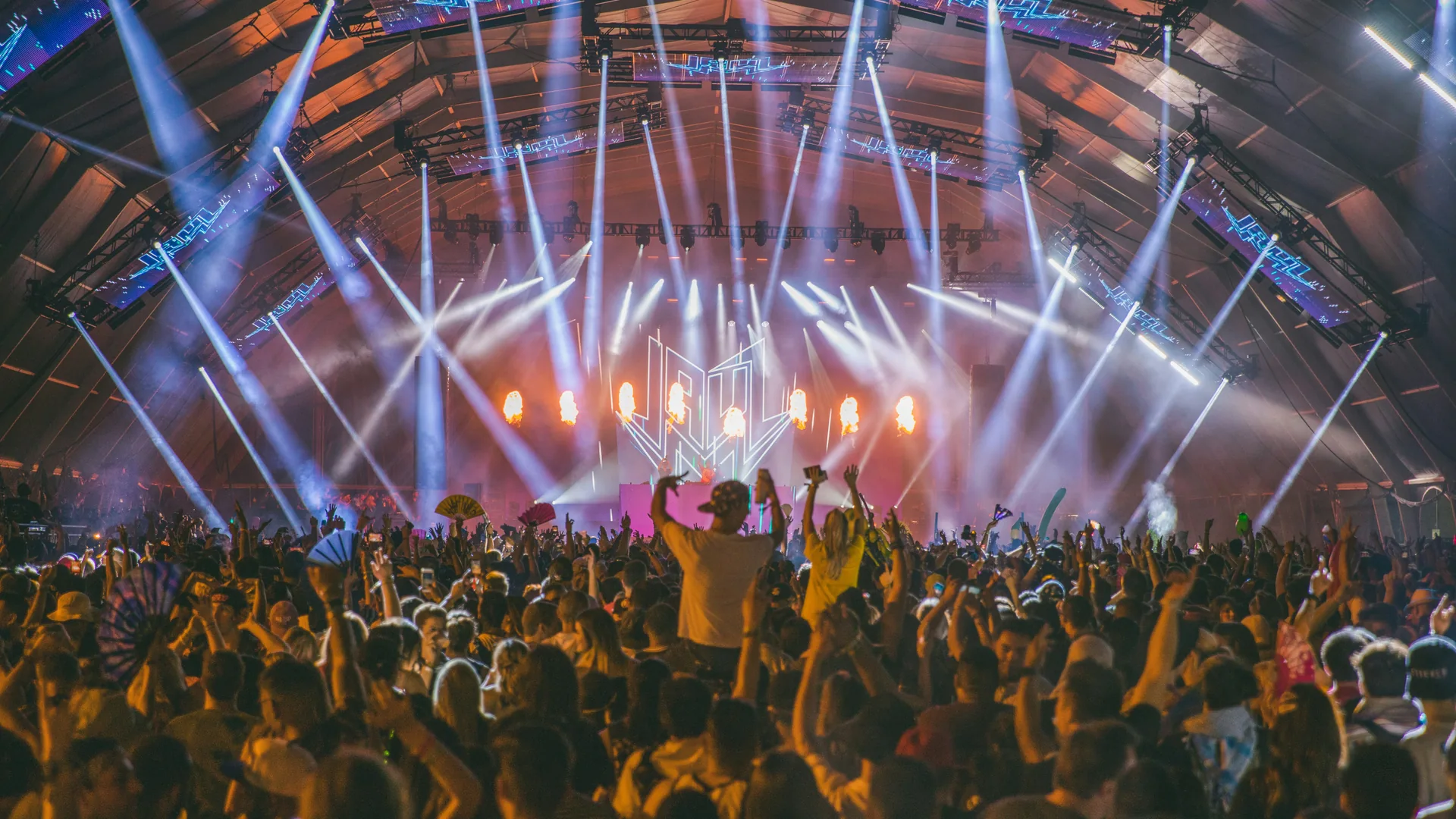 A large crowd enjoying an outdoor live music festival